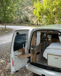 the back end of a van with its door open and bed pulled up to it