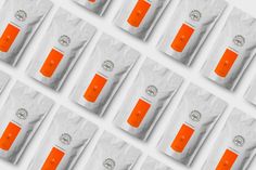 an array of orange and white coffee bags