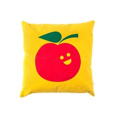 a yellow pillow with a red apple on the front and green leaf on the back