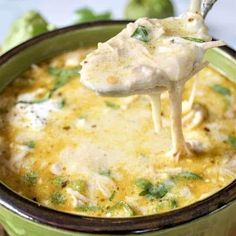 a spoon full of chicken and cheese soup