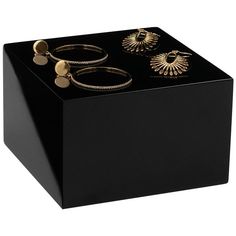 a black box with three rings and two earring sets on it's sides