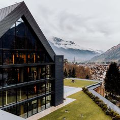 an aerial view of a building with mountains in the background