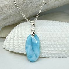 This beautiful high quality Larimar cabochon is a sky blue with no imperfections, as Larimar often has. This piece is so reminiscent of being at the beach, with it's seaside-like colors and white "waves"!  This lovely pendant will come on a dainty .925 sterling silver chain and a sterling silver lobster clasp.  If you have any questions, please just ask and I will be happy to help you. I have also included a diagram in the photo section to assist with necklace chain sizing. To order: *In the drop-down menu, please choose the Pendant With Chain and your Necklace Chain length (keeping in mind that the pendant is 1.5" tall). *It's no surprise that Larimar is a water stone; it has that ebbing energy of light dancing across the water and it seems to be infused with a sense of cleansing calm.  I Light Blue Sterling Silver Round Necklace, Light Blue Oval Gemstone Necklaces, Light Blue Round Sterling Silver Necklace, Larimar Gemstone Pendant Necklaces, Larimar Gemstone Pendant Necklace, Oval Blue Larimar Jewelry, Handmade Light Blue Sterling Silver Necklaces, Handmade Light Blue Sterling Silver Necklace, Handmade Larimar Round Necklace