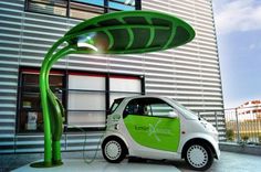 an electric car charging in front of a building with a large green plant on the roof