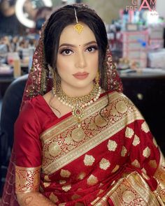 a woman in a red and gold sari with her hands on her hips, looking at the camera