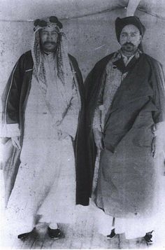 an old photo of two men standing next to each other wearing hats and scarves