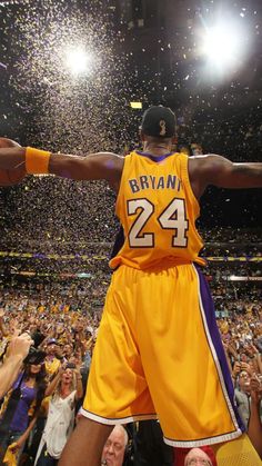 a basketball player holding his arms out in the air with confetti all around him