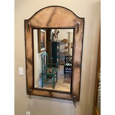 a mirror that is on the wall above a table and chair in front of it