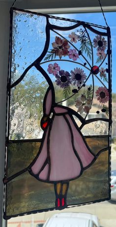 a stained glass window with a girl holding flowers