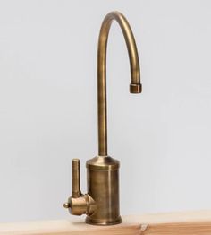 an antique brass faucet on a wooden counter