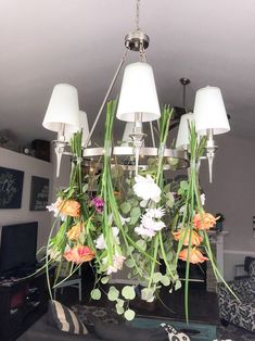 a chandelier with flowers hanging from it's ceiling in a living room