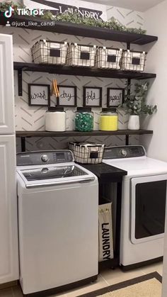 a washer and dryer in a laundry room with shelves above it that have baskets on them