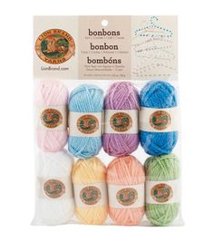 six skeins of yarn in assorted colors and the packaging for each item