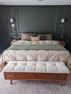 a bedroom with a bed, ottoman and two lamps on either side of the bed