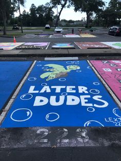 a parking lot that has been painted with different colors and designs on it, along with the words later dudes