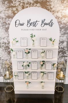 the wedding seating display is decorated with white flowers and greenery