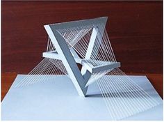 an origami sculpture sitting on top of a piece of paper