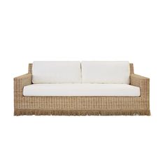 a wicker couch with white cushions and fringes on the armrest, against a white background