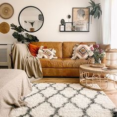 a living room filled with furniture and lots of pillows on top of a white rug