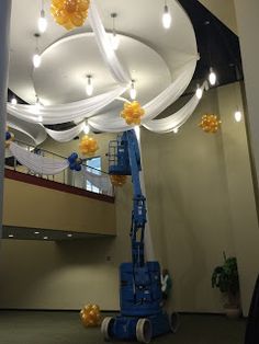 the ceiling is decorated with yellow and white balloons