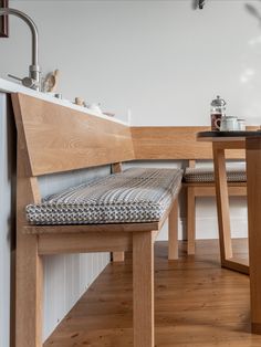 a wooden table with two chairs and a bench in front of it on top of a hard wood floor