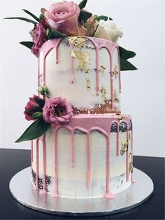 a white and pink cake with flowers on top