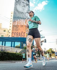 a woman running down the street with tattoos on her leg