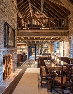 a large dining room with stone walls and wooden tables in front of a fire place