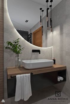 a white sink sitting under a mirror in a bathroom next to a wooden counter top