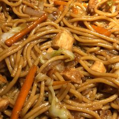 noodles with chicken and carrots are mixed together in a dish that is ready to be eaten