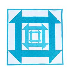 a blue and white quilted square with an arrow in the center on a white background