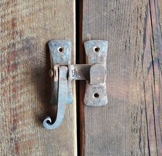 an old wooden door with a metal handle on the front and side of it's hinge