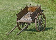 an old wooden wagon sitting in the grass