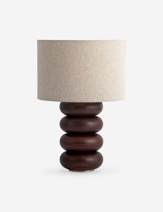 a wooden table lamp with a white shade on it's top and bottom half