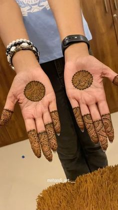 two hands with henna designs on them