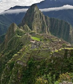 the ruins of machaca picach are surrounded by greenery and mountains in the background