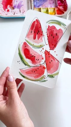 someone is painting watermelon slices on paper