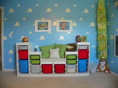 a child's room with blue walls and clouds painted on the wall behind it