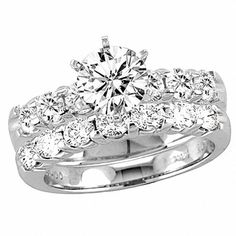 a wedding ring set with two matching bands and a round diamond center stone on the band