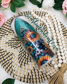 a coffee cup sitting on top of a table next to some beads and flowers in the background