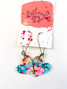 a pair of heart shaped earrings hanging from a card with the words, happy birthday joy