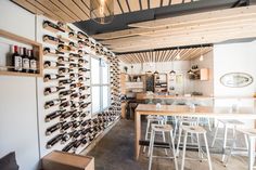 a room filled with lots of bottles of wine on the wall next to a table and chairs