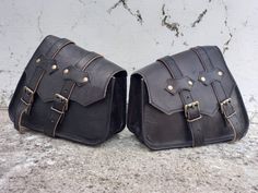 "Leather Saddle bags Motorcycle Black Leather Saddlebags Panniers 2 Side Luggage Leather Bags for Motorcycles Handmade Black Leather bag is perfect to use as a : Motorcycle bag, bike bag, saddle bag, side bag for bike, motorbike luggage bag. Leather - Goat leather Color - Black Buckles - Brass Size - 11\" x 9\" x 4\" inch ( Height x Width x Depth ) Features : One main compartment to use your personal belongs. High Quality Goat hide saddle bags for bike. The inner lining of the bag is sturdy canv Leather Biker Bag For Everyday Use, Biker Style Leather Travel Bag, Black Leather Adventure Bag, Motorcycle Panniers, Leather Corporate Gifts, Women Sling Bags, Sling Bags Women, Sling Bag Men, Motorcycle Saddlebags