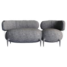 a gray couch and ottoman sitting on top of a white floor next to each other