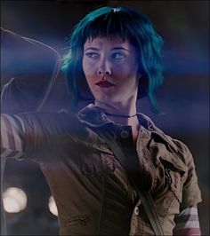 a woman with blue hair holding a cell phone