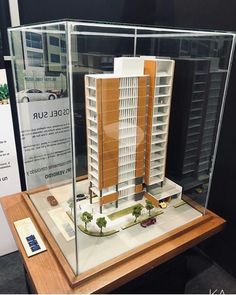 a model of a building on display in a glass case with wood trimmings