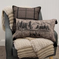 a chair with two pillows on it and a blanket in front of the chair,