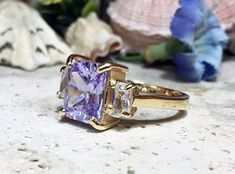 Don't miss this opportunity to own this beautiful gemstone ring crafted in 14k gold filled => Gemstone Type - Lab Grown Amethyst, Clear Quartz => Gemstone Cut - Faceted => Gemstone Size - 8*10 mm, 3*5 mm => Total Number of Gemstones - 3 => Metal Type - 14k Gold Filled (Tarnish Resistant And Nickel Free) - also available in 925 sterling silver * Please contact me for pricing on a sizes larger than 11 * ~ Feel free to ask me about custom made designs. ❏ Replacements and custom order Rectangular Sapphire Ring For Anniversary, Rectangular Sapphire Ring With Prong Setting As Gift, Rectangular Sapphire Promise Ring, Rectangular Three Stone Jewelry As A Gift, Three Stone Rectangular Jewelry Gift, Rectangular Three Stone Jewelry Gift, Rectangular Sapphire Wedding Ring, Rectangular Topaz Ring With Prong Setting For Promise, Rectangular Topaz Ring For Wedding