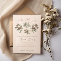 the wedding card is next to some flowers