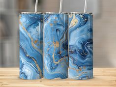 three blue and gold canisters sitting on top of a wooden table